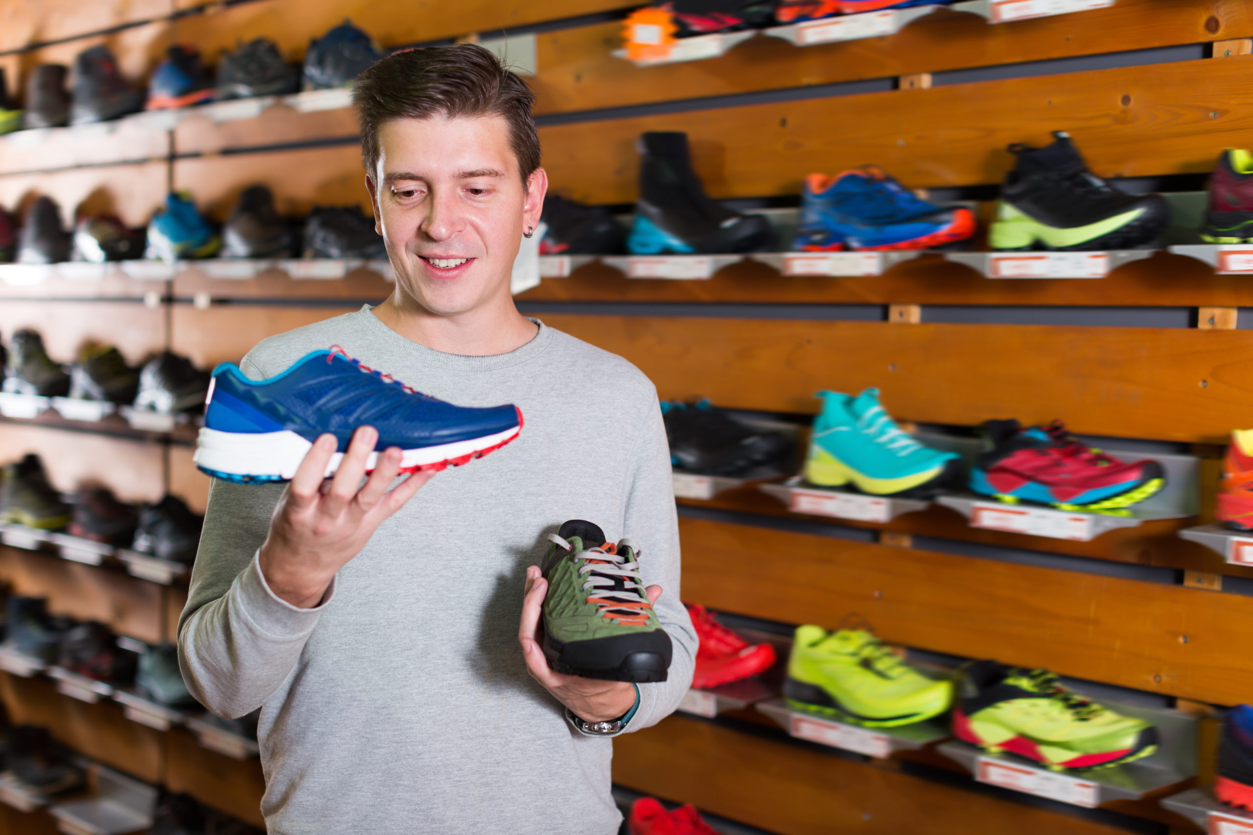 Мужчина выбирает обувь. Поменялись обувью. Стоковые фото спортивные магазины. Sport Shoes Store.